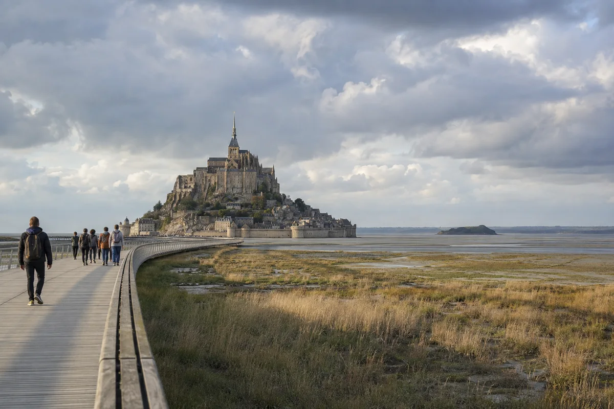 Des visiteurs approchent le Mont-Saint-Michel par la passerelle au bord de la baie